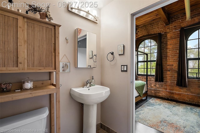 6533 E Jefferson Ave Unit 312W, Detroit, MI 48207 - bathroom with brick wall and beam ceiling