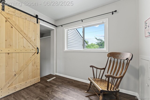 4860 Lindholm Dr, White Lake, MI 48383 - sitting room featuring a barn door and dark wood-style flooring