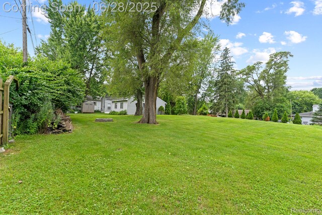 4860 Lindholm Dr, White Lake, MI 48383 - view of grassy yard featuring a storage shed