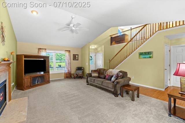 12366 Orchard Wood Dr, Fenton, MI 48430 - carpeted living area with lofted ceiling, ceiling fan, a fireplace with flush hearth, and stairs