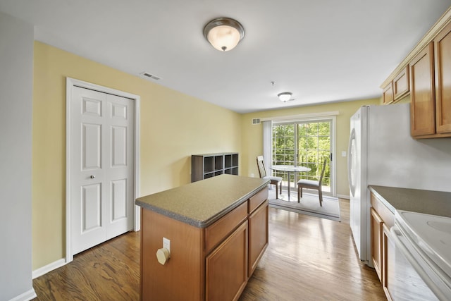 662 Village Ln, Milford, MI 48381 - kitchen with dark countertops, dark wood-style flooring, brown cabinets, a center island, and white electric range