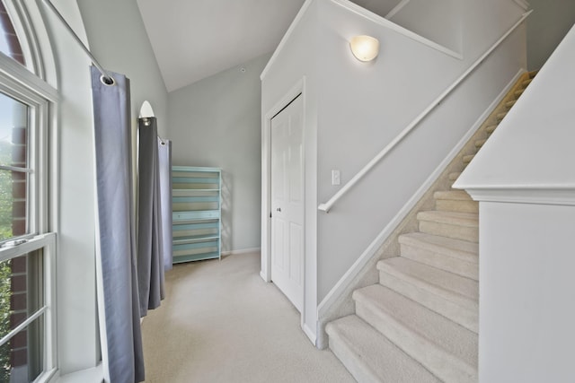 662 Village Ln, Milford, MI 48381 - hallway with light colored carpet, stairway, and lofted ceiling