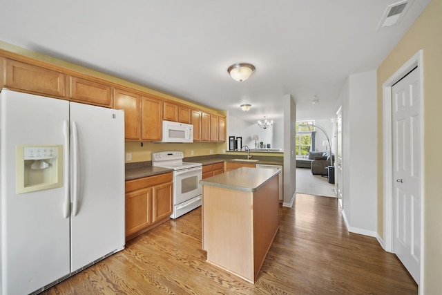 662 Village Ln, Milford, MI 48381 - kitchen featuring white appliances, light wood finished floors, a center island, a peninsula, and open floor plan