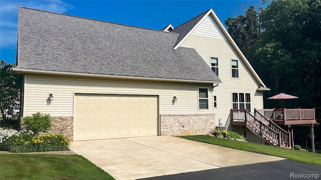 5580 Birch Ln, Davisburg, MI 48350 - back of house featuring brick siding, a wooden deck, driveway, a shingled roof, and an attached garage