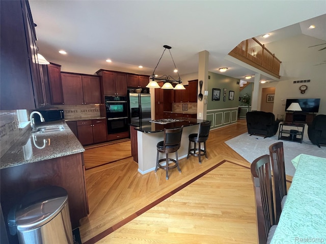 5580 Birch Ln, Davisburg, MI 48350 - kitchen featuring stainless steel appliances, a kitchen bar, open floor plan, backsplash, and pendant lighting