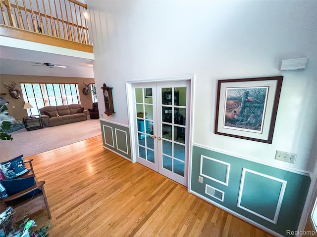 5580 Birch Ln, Davisburg, MI 48350 - entryway featuring french doors, a towering ceiling, wood finished floors, wainscoting, and a ceiling fan