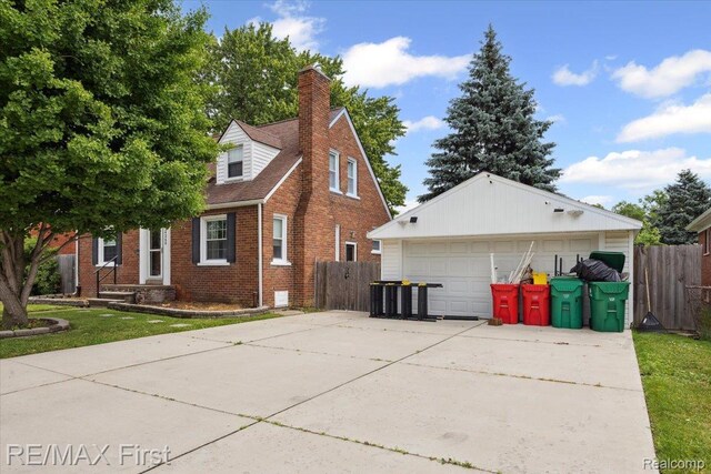 24360 Grove Ave, Eastpointe, MI 48021 - view of home's exterior with brick siding, a detached garage, a chimney, and an outdoor structure