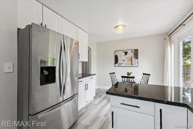24360 Grove Ave, Eastpointe, MI 48021 - kitchen featuring stainless steel refrigerator with ice dispenser, white cabinetry, light wood-style floors, and dark stone countertops
