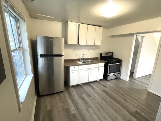 2017 Eastport St, Westland, MI 48186 - kitchen featuring appliances with stainless steel finishes, wood finished floors, dark countertops, and white cabinets
