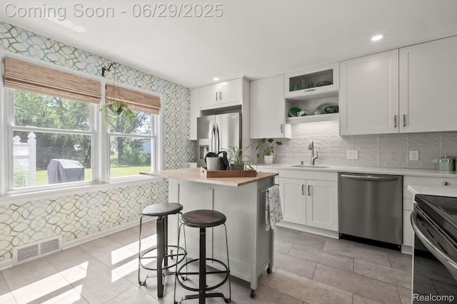 187 Gateway Dr, Waterford, MI 48328 - kitchen featuring stainless steel appliances, a kitchen bar, white cabinetry, decorative backsplash, and recessed lighting