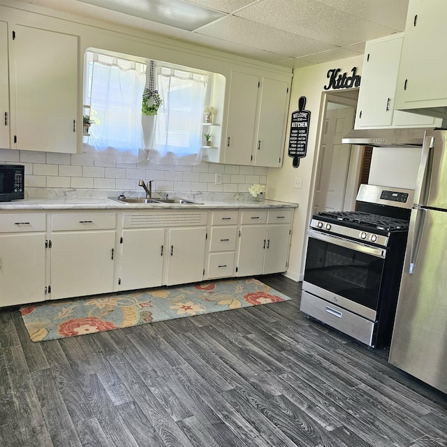 1418 Birney St, Saginaw, MI 48602 - kitchen with appliances with stainless steel finishes, dark wood-style flooring, decorative backsplash, light countertops, and white cabinetry