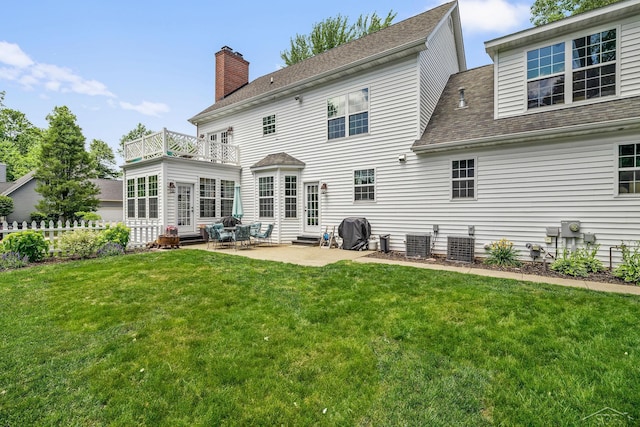 12449 Northway Pkwy, Freeland, MI 48623 - rear view of property featuring a balcony, entry steps, a lawn, a patio area, and a chimney