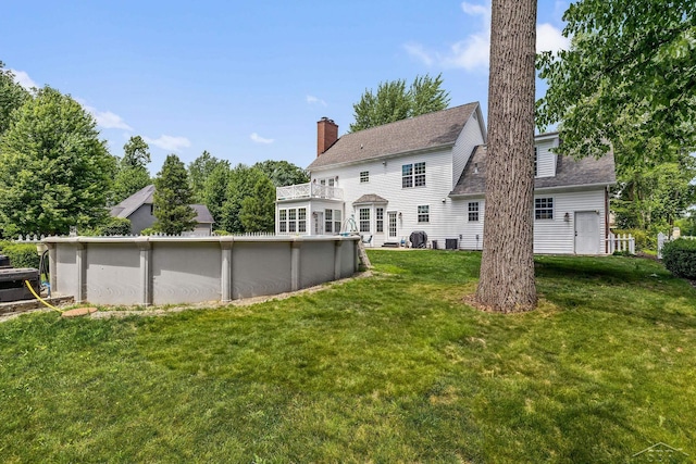 12449 Northway Pkwy, Freeland, MI 48623 - rear view of property with a lawn, an outdoor pool, and a chimney