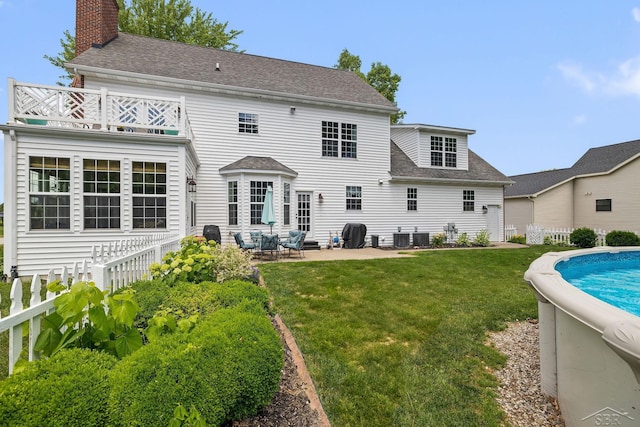 12449 Northway Pkwy, Freeland, MI 48623 - rear view of property featuring a shingled roof, a balcony, a patio, and a chimney