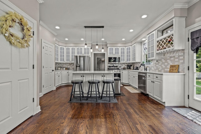 12449 Northway Pkwy, Freeland, MI 48623 - kitchen with appliances with stainless steel finishes, a kitchen breakfast bar, a center island, tasteful backsplash, and white cabinets