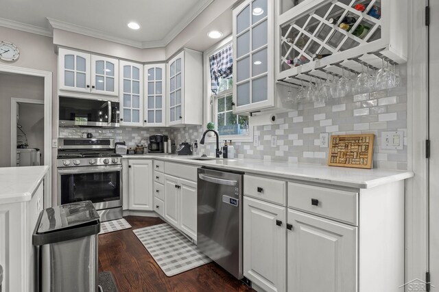 12449 Northway Pkwy, Freeland, MI 48623 - kitchen featuring appliances with stainless steel finishes, crown molding, tasteful backsplash, white cabinets, and dark wood-style floors