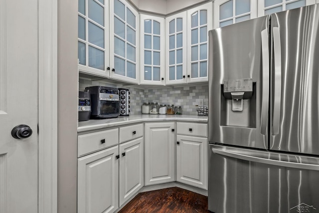 12449 Northway Pkwy, Freeland, MI 48623 - kitchen with stainless steel fridge, light countertops, backsplash, white cabinetry, and glass insert cabinets