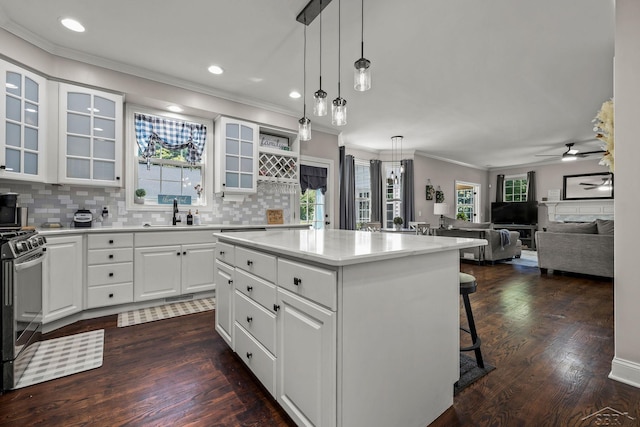 12449 Northway Pkwy, Freeland, MI 48623 - kitchen with stainless steel gas range, crown molding, dark wood-style flooring, decorative backsplash, and a kitchen island