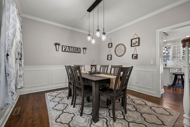12449 Northway Pkwy, Freeland, MI 48623 - dining space with dark wood finished floors, crown molding, wainscoting, a chandelier, and a decorative wall