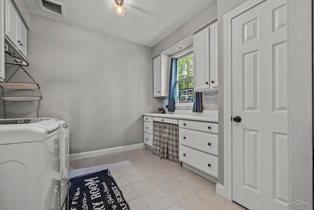 12449 Northway Pkwy, Freeland, MI 48623 - washroom with washing machine and clothes dryer, cabinet space, and light tile patterned flooring