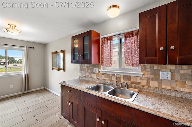 27043 Lorenz St, Madison Heights, MI 48071 - kitchen with decorative backsplash, glass insert cabinets, light countertops, and light wood-type flooring