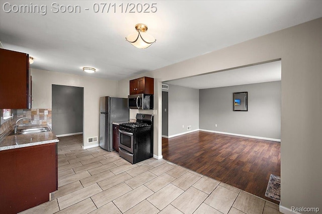 27043 Lorenz St, Madison Heights, MI 48071 - kitchen featuring stainless steel appliances, light wood-style floors, open floor plan, and decorative backsplash