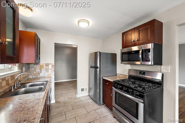 27043 Lorenz St, Madison Heights, MI 48071 - kitchen featuring appliances with stainless steel finishes, decorative backsplash, light countertops, glass insert cabinets, and light tile patterned floors