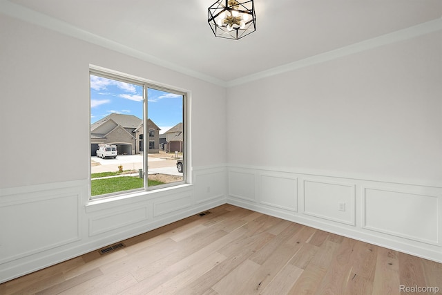 53650 Romeo Plank Rd, Macomb, MI 48042 - unfurnished room featuring a wainscoted wall, a chandelier, light wood-style flooring, and crown molding