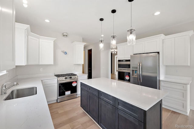 53650 Romeo Plank Rd, Macomb, MI 48042 - kitchen featuring appliances with stainless steel finishes, white cabinetry, a center island, light wood-style floors, and decorative light fixtures