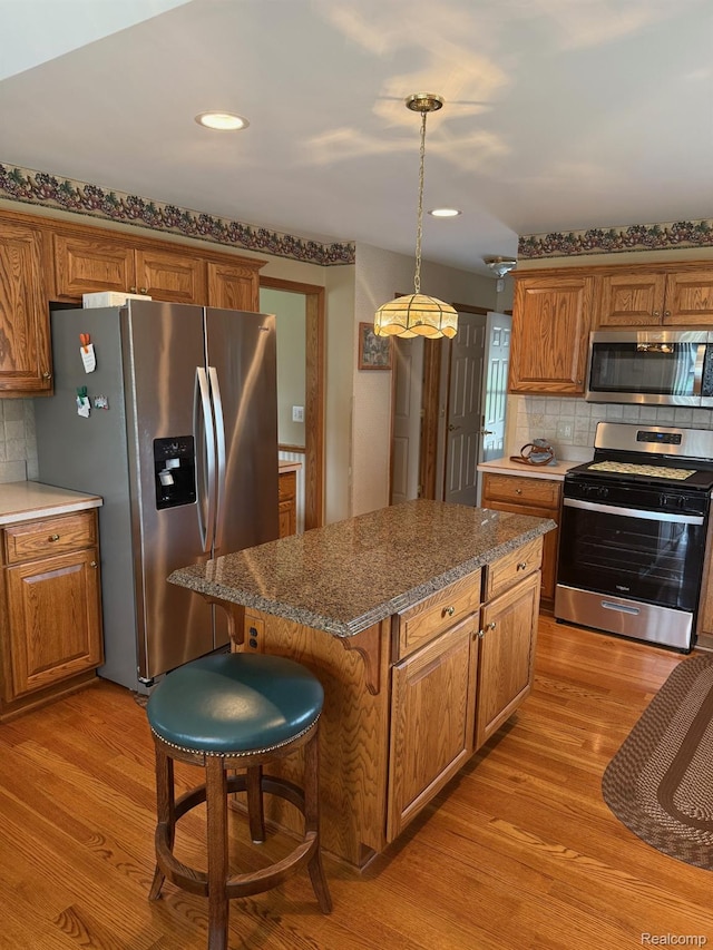 35851 Ireneus Dr, New Baltimore, MI 48047 - kitchen featuring stainless steel appliances, light wood-style floors, tasteful backsplash, brown cabinets, and recessed lighting