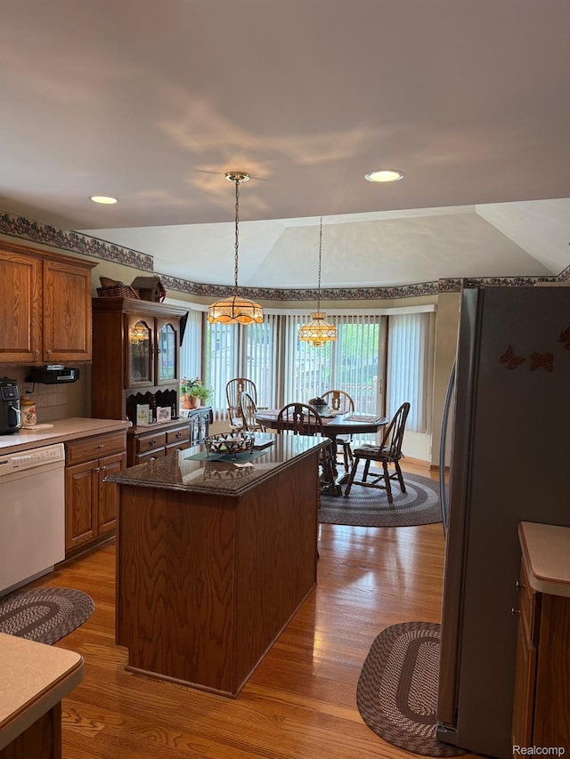 35851 Ireneus Dr, New Baltimore, MI 48047 - kitchen with freestanding refrigerator, white dishwasher, dark wood-type flooring, a chandelier, and a kitchen island