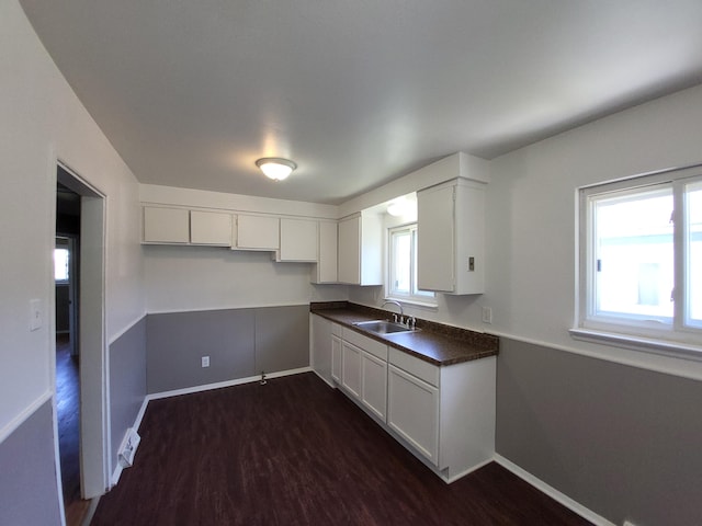 6163 Glenis St, Taylor, MI 48180 - kitchen with dark countertops, dark wood-style floors, and white cabinetry