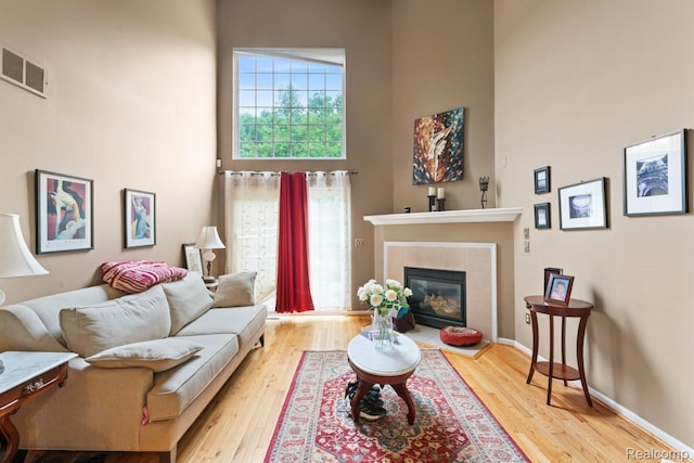 2255 Crystal Crossing Dr, Howell, MI 48843 - living room with a high ceiling, wood finished floors, and a fireplace