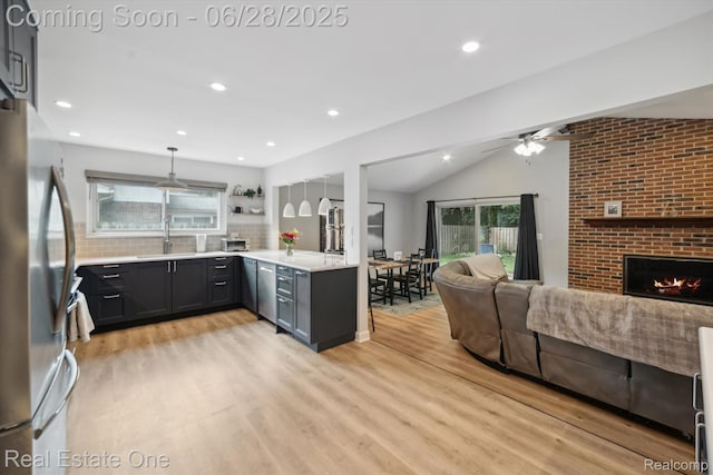 8409 Sandpiper St, Canton, MI 48187 - kitchen featuring freestanding refrigerator, light wood finished floors, open floor plan, light countertops, and lofted ceiling