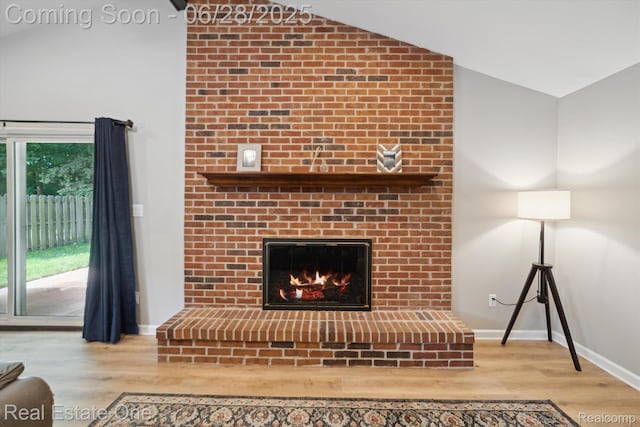 8409 Sandpiper St, Canton, MI 48187 - living room featuring lofted ceiling, wood finished floors, plenty of natural light, and a brick fireplace