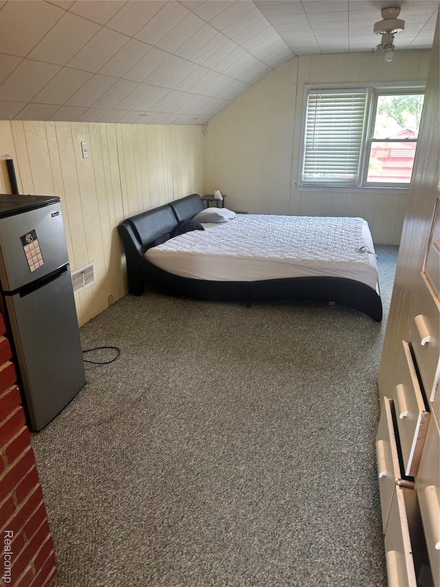 967 Hubbard Ave, Flint, MI 48503 - carpeted bedroom featuring freestanding refrigerator, lofted ceiling, and wooden walls