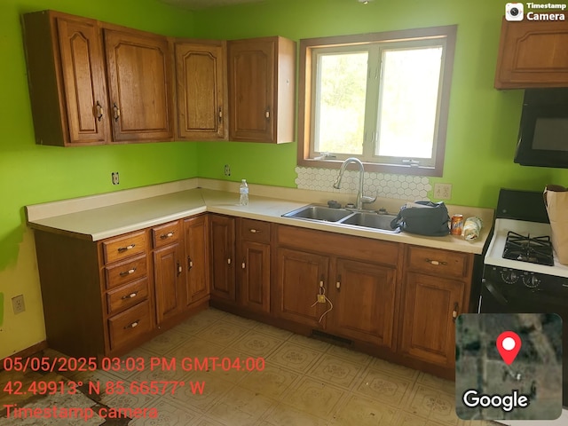 1075 12th St, Martin, MI 49070 - kitchen featuring black microwave, brown cabinets, light countertops, and gas range oven