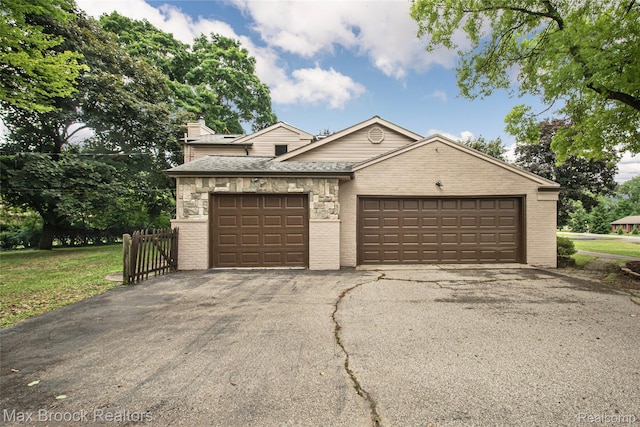 6730 Halyard Rd, Bloomfield Hills, MI 48301 - view of front of house with brick siding, a garage, a chimney, and asphalt driveway