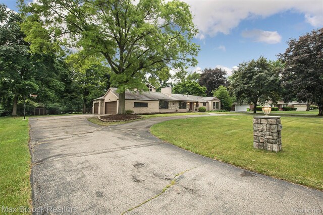 6730 Halyard Rd, Bloomfield Hills, MI 48301 - single story home with asphalt driveway, a front yard, a chimney, view of scattered trees, and a garage