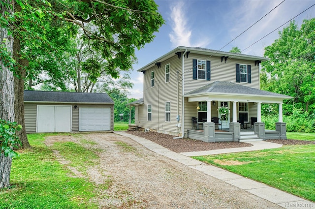 405 Garden Ln, Fowlerville, MI 48836 - view of front of house featuring driveway, covered porch, an outbuilding, a garage, and a front lawn