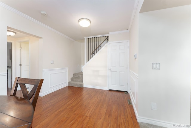 405 Garden Ln, Fowlerville, MI 48836 - entryway featuring wood finished floors, stairway, crown molding, and a wainscoted wall