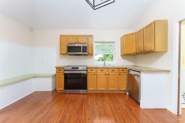 405 Garden Ln, Fowlerville, MI 48836 - kitchen with appliances with stainless steel finishes, wood finished floors, light countertops, and lofted ceiling