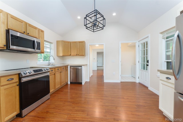 405 Garden Ln, Fowlerville, MI 48836 - kitchen featuring stainless steel appliances, light countertops, light brown cabinets, vaulted ceiling, and recessed lighting