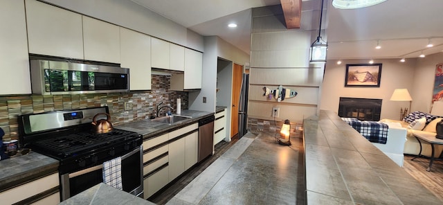3400 Lakeside Dr S Unit 17, Petoskey, MI 49770 - kitchen with appliances with stainless steel finishes, dark countertops, backsplash, and white cabinetry