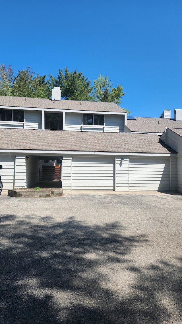 3400 Lakeside Dr S Unit 17, Petoskey, MI 49770 - view of front facade with a garage, asphalt driveway, and roof with shingles