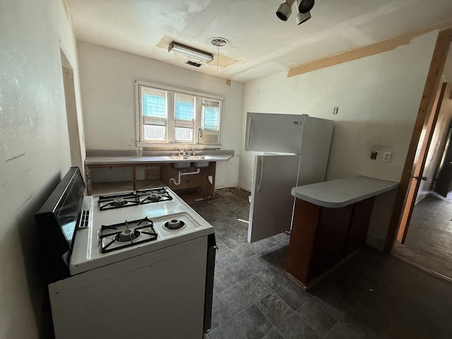 223 Washington Ave, Lakeview, MI 48850 - kitchen with white range with gas cooktop, a peninsula, freestanding refrigerator, and light countertops