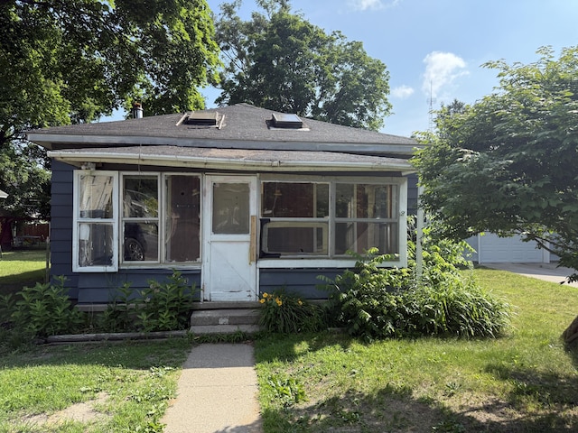 223 Washington Ave, Lakeview, MI 48850 - view of front facade with a sunroom, a shingled roof, and a front lawn