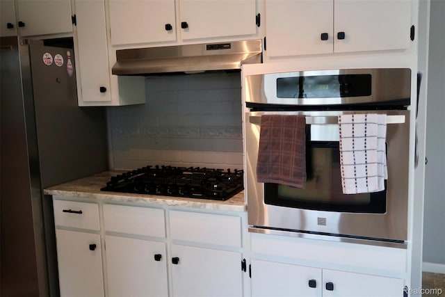 28242 Aline Dr, Warren, MI 48093 - kitchen with appliances with stainless steel finishes, under cabinet range hood, tasteful backsplash, and white cabinets