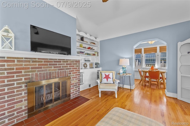 108 Highland Ave, Lake Orion, MI 48362 - living area with arched walkways, wood finished floors, a fireplace, and built in shelves