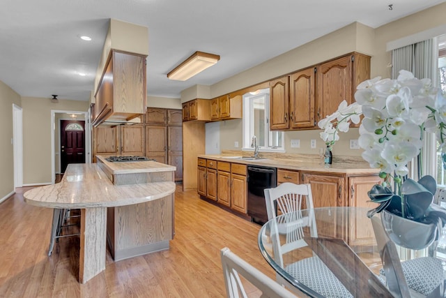 5951 Riverside Dr, Jackson, MI 49201 - kitchen with dishwasher, light countertops, brown cabinets, and light wood-style flooring